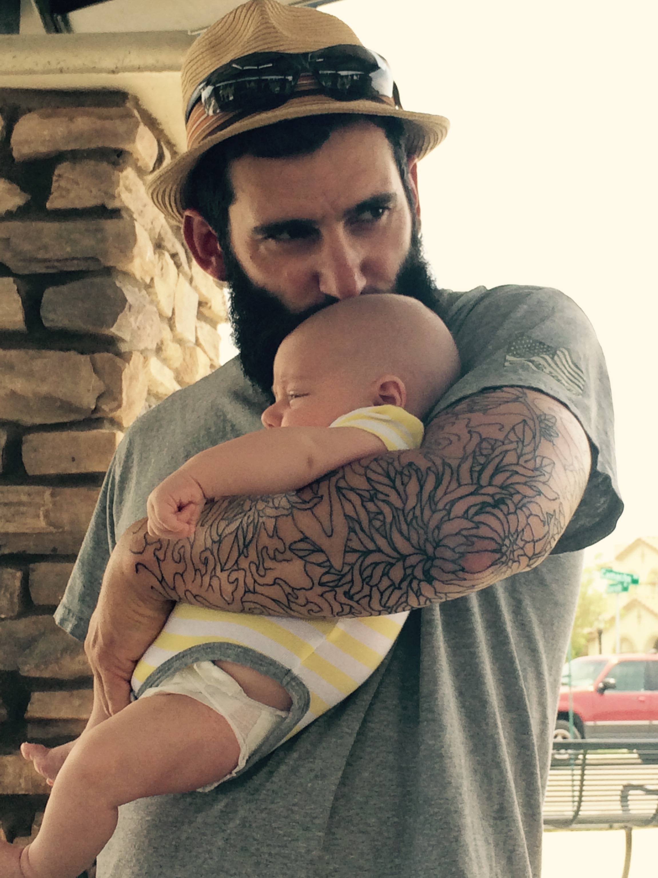 Mac kissing the head of a baby who isn't ours but is kind of ours.
